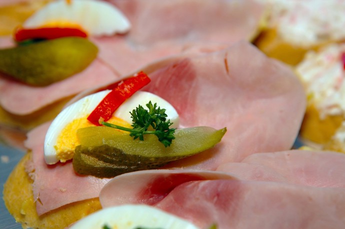 Kyselá okurka, plátek vajíčka a petrželka – nepostradatelná součást tradičního šunkového chlebíčku.