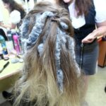 Zde detail vlasů zezadu. Jsou natupírované a zapletené do strany. Nechybí doplňky, které mají naznačovat, že jde o zvířecí roli. 