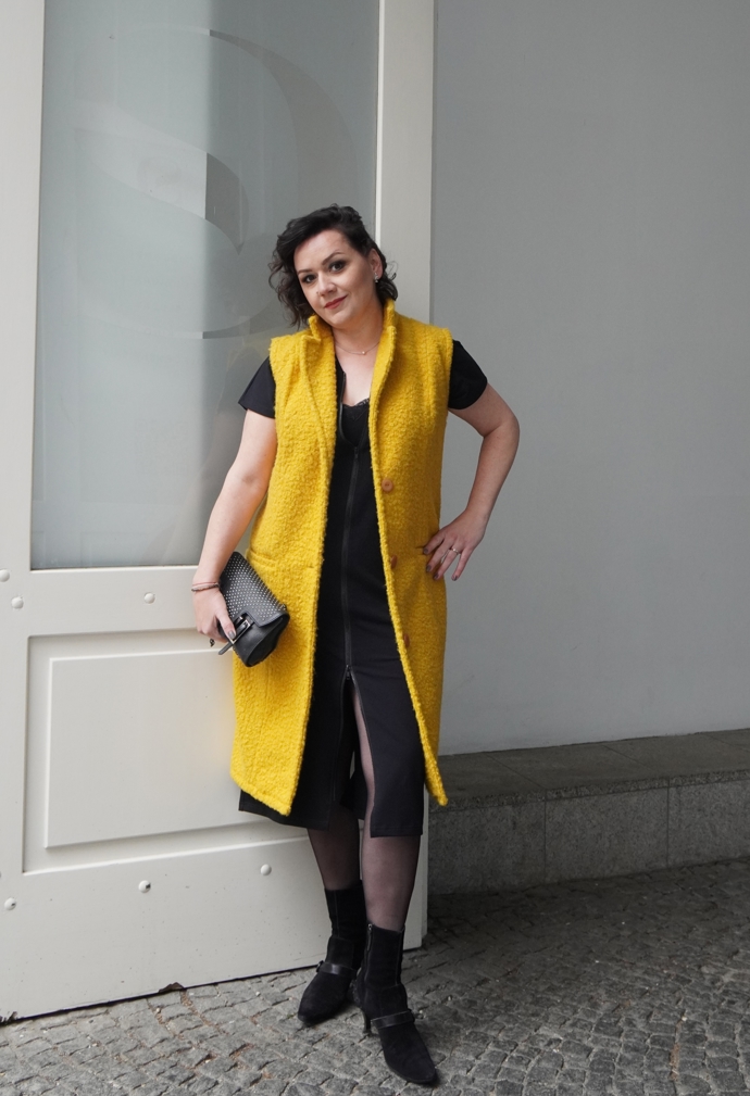 Šéfredaktorka Markéta Behinová v černých šatech Mikela da Luka, žluté vestě z dílny Martiny Pipkové Loudové a černých kozačkách Tods. To vše navíc doplnila o kabelku značky Coccinelle.  