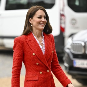 Černá krokodýlí kabelka, kterou Kate doplnila outfit tvořený černými kalhotami a červeným sakem.