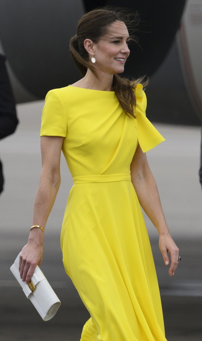 Kate Middleton v elegantních žlutých šatech, ke kterým zvolila jednoduché bílé psaníčko se zlatým detailem. 