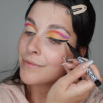 Po nanesení jemně broskvového stínu přes korektor vytvořte kočičí linku, která vede od vnitřního koutku oka.