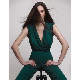 Lahvově zelený dámský overal pro změnu předvádí modelka Aneta Vignerová.