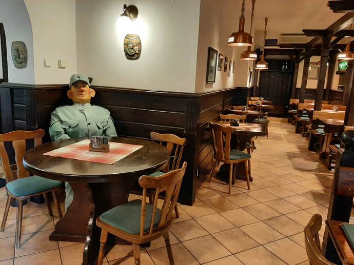 Interiér restaurace je zařízený v podobném stylu. Nechybí Švejk a stolů je opravdu dostatek, takže nehrozí, že byste si neměli kam sednout.
