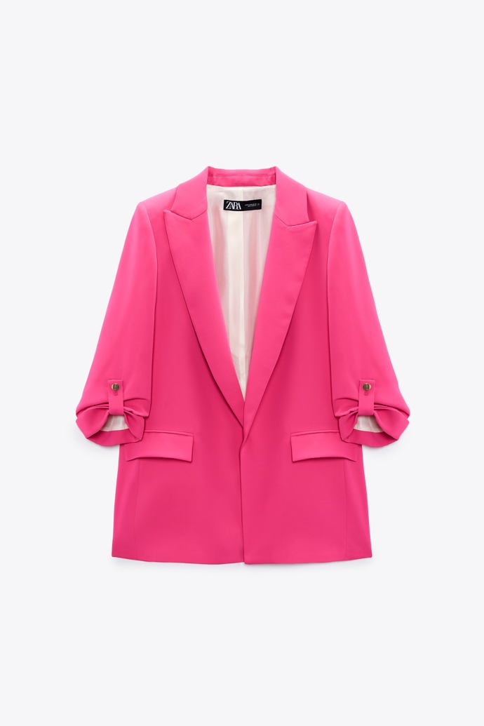 Růžové sako s klopami do špičky a rukávy v délce pod loket s ohrnutím a připínacími pásky a zlatými knoflíky. ZARA, 1199 Kč