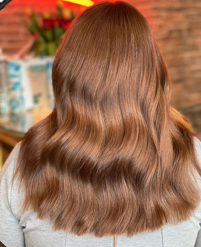 Karamelově hnědá barva, která se na slunci leskne jako jantar. Perfektní vlny vytvořili v salonu Hairtrend.