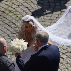 Lela se svým tatínkem, který jí drží kytici růží.