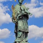 S Karlovým mostem se nepojí jen přírodní katastrofy, ale také postava světce Jana Nepomuckého, který měl být z mostu svržen dolů.