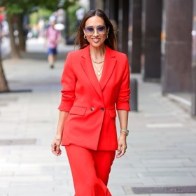 Myleene Klass v neonově červeném kalhotovém kostýmu, který doplnila černými sandály na klínku a zlatými šperky.