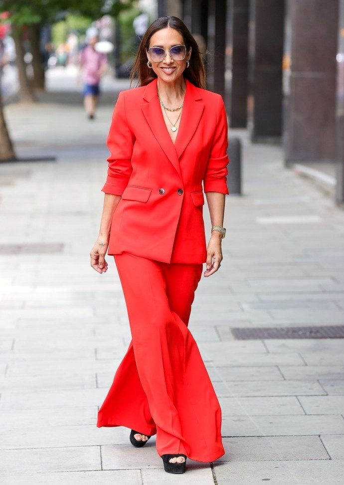Myleene Klass v neonově červeném kalhotovém kostýmu, který doplnila černými sandály na klínku a zlatými šperky.