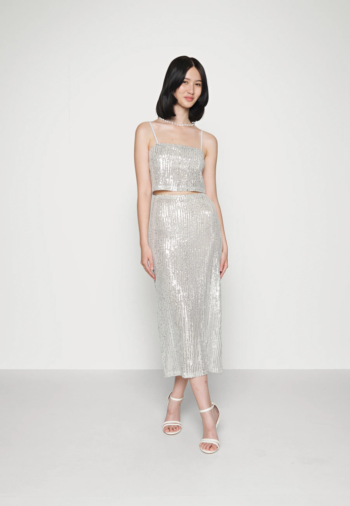 Pokud tedy i vás letos čeká akce, která si žádá trendy outfit, nechte se hereččiným modelem inspirovat. Sukně s flitry NA-KD. Zalando, 904 Kč