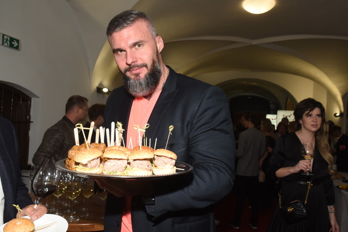 Přítel Lucie Bílé na večírku nabízel hostům lahůdky a jeho tričko barevně ladilo s kostýmem zpěvačky.