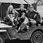 Tady to všechno začalo. Na fotografii ze září 1972 jsou Loretta Swit (Margaret Houlihanová), Wayne Rogers (Trapper John), McLean Stevenson (Henry Blake) a Alan Alda (Hawkeye Pierce).