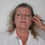 Postupně jsem ho ztmavila a aplikovala ho do vnitřního koutku, aby se vytvořila větší hloubka líčení. Do středu víčka jsem použila světlý třpytivý stín pro rozjasnění. Oči jsem doplnila linkou.