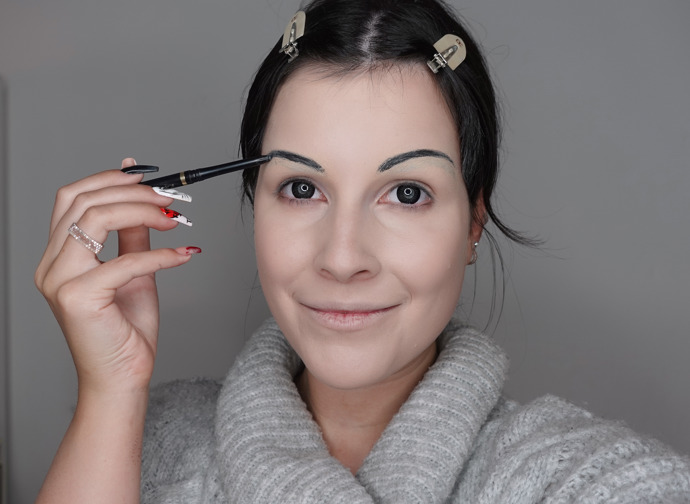 Před líčením jsem svoje obočí zakryla pomocí lepidla a make-upu, abych si mohla překreslit obočí nové, které by se více podobalo tomu Morticiinu. Základem je velmi světlý make-up, který jsem houbičkou nanesla na celý obličej. Následovalo překreslení obočí nejprve pomocí černé tužky. Pro jeho realističtější a výraznější vzhled jsem ho dokreslila ještě fixou na obočí.