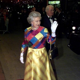 Královna Alžbeta II. a její vtipné barevné šaty, které oblékla při královském varietním představení v listopadu 1999.