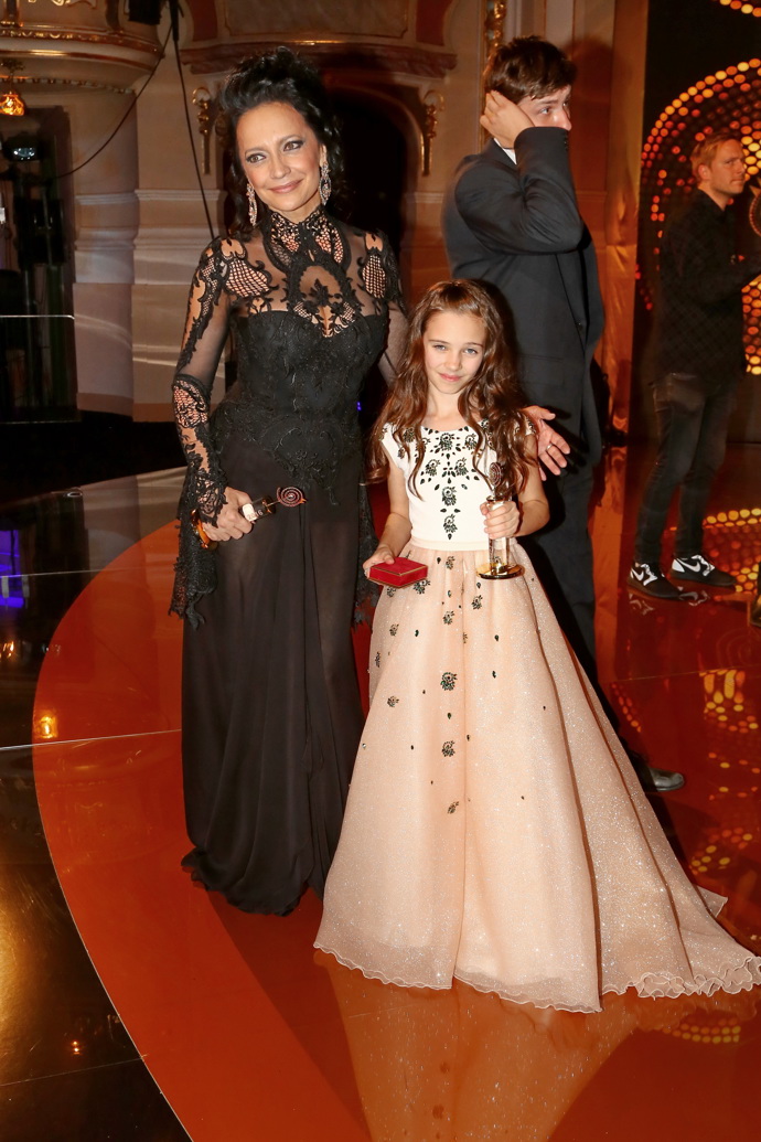 Lucie Bílá v roce 2016, kdy na slavnostní večer vynesla černou krajkovanou róbu. Na snímku s dcerou Karla Gotta Charlotte, jejíž šaty jsou pošity jeho slavíky.