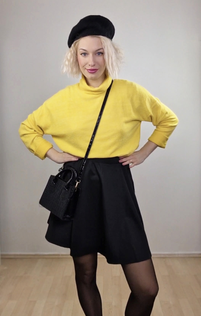 Žlutý svetr v kombinaci s černými doplňky.