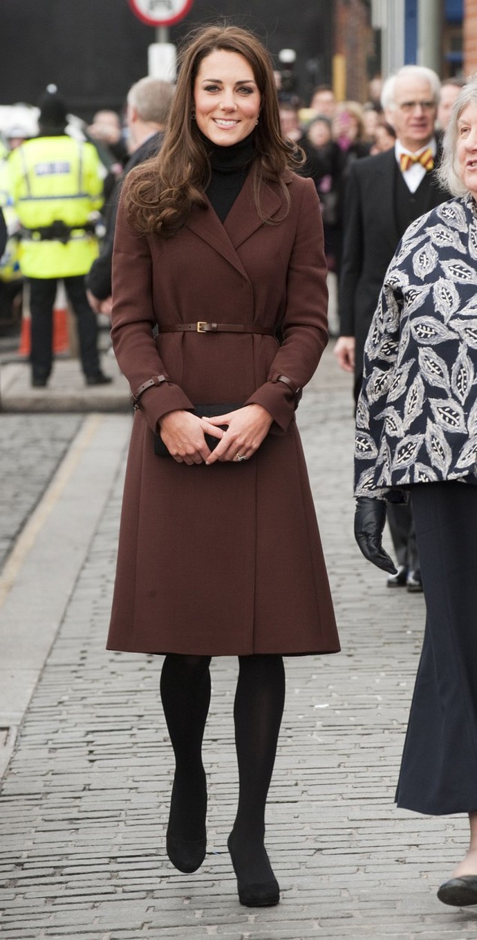 Kate Middleton v kaštanově hnědém kabátu značky Hobbs v roce 2012. Všimněte si délky těsně pod kolena. 