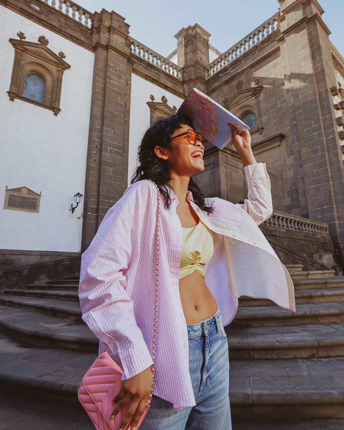 Vytvořte svrchní vrstvu z klasické košile. Stačí pod ni obléci zkrácené tričko, tílko či bandeau top jako na snímku z kolekce Clockhouse pro jaro/léto 2023 a máte připravenu perfektní kombinaci k džínám či džínové sukni.