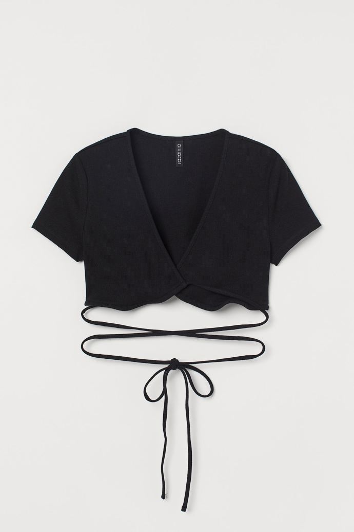 Crop topy se zavinovací optikou patří k velmi oblíbeným nejen díky efektnímu prvku několikrát ovinuté tkaničky vázačky. Univerzální top H&M (299 Kč) najdete v obchodě také v bílé barvě.