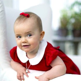 Princezna Estelle byla roztomilá parádnice už jako miminko. Sotva jí začaly růst vlásky, už dostala slušivou mašličku. V červených šatečkách s klasickým bílým límcem je navíc nepřehlédnutelná.