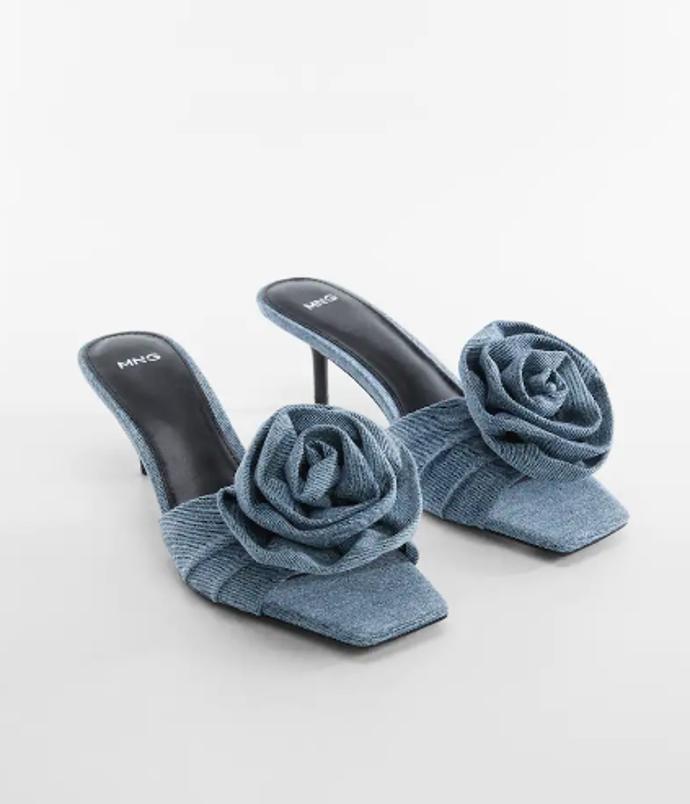 Květinové aplikace skvěle doplňují i pantoflíčky. Jejich džínové provedení s jehlovými podpatky najdete v nabídce řetězce Mango za 1 999 kč.