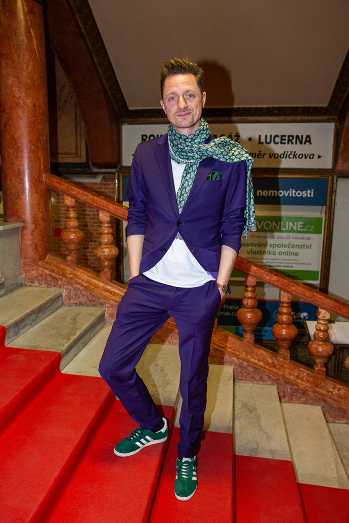 Zpěvák Ondřej Ruml si v seriálu zahrál Karla Gotta. Do Lucerny oblékl tmavě fialový oblek, který doplnil výraznou šálou.