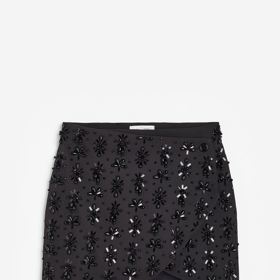 Poněkud propracovanější povrh představuje korálky pošitá minisukně H&M (4 499 Kč), kterou můžete pořídit i v setu se stejně zpracovaným krátkým blejzrem.