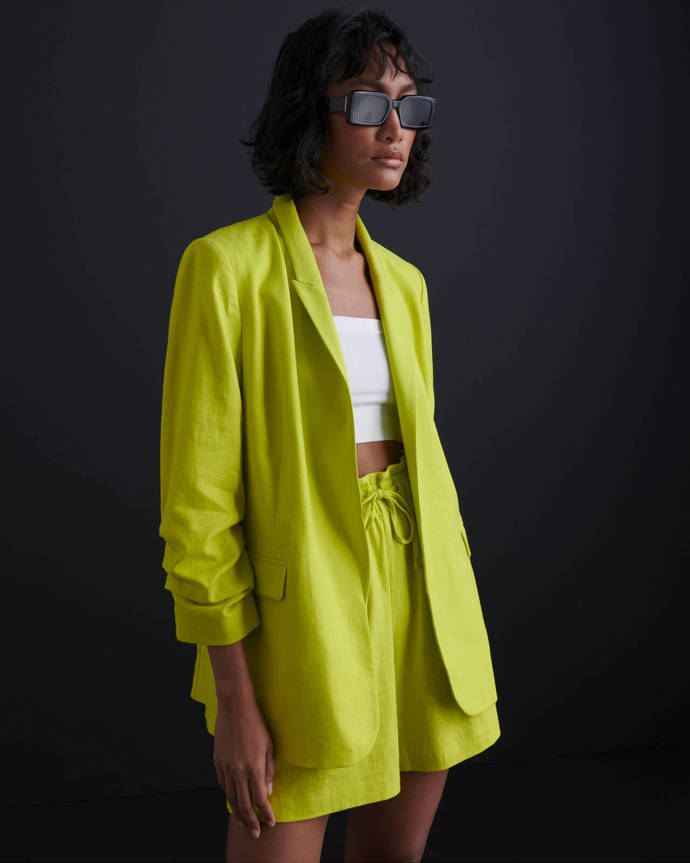 Vyletněná varianta z nabídky Marks&Spencer disponuje krátkými kalhotami, ležérním volným střihem a nepřehlédnutelnou barvou. Sako, cena 1799 Kč, šortky, cena 899 Kč