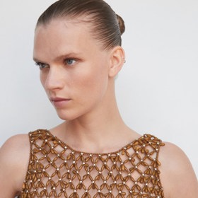 Korálkový top Mango významně odhaluje kůži. Je vhodný přes prádlové živůtky či jednoduchá basic trička. Cena: 2 999 Kč