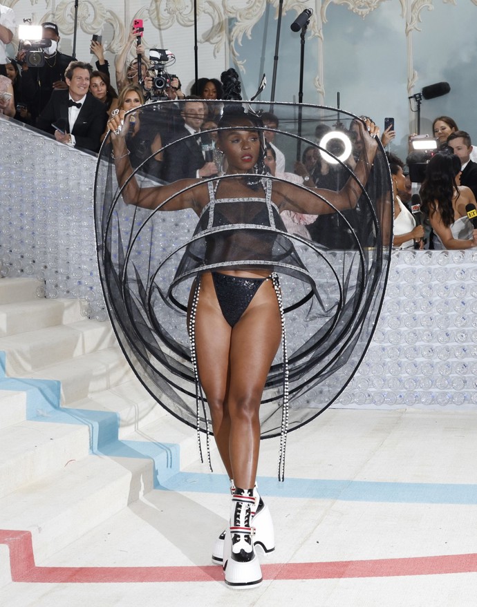 Když odhodila buklé kabátek, odhalila pravý důvod své kuželovité siluety. Krinolína z průsvitného tylu dala prostor odhalit téměř vše, včetně nepřehlédnutelného obutí.