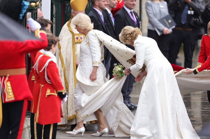 Královna Camilla oblékla bílé šaty se zlatým vyšíváním od oblíbeného návrháře princezny Diany Bruce Oldfielda.