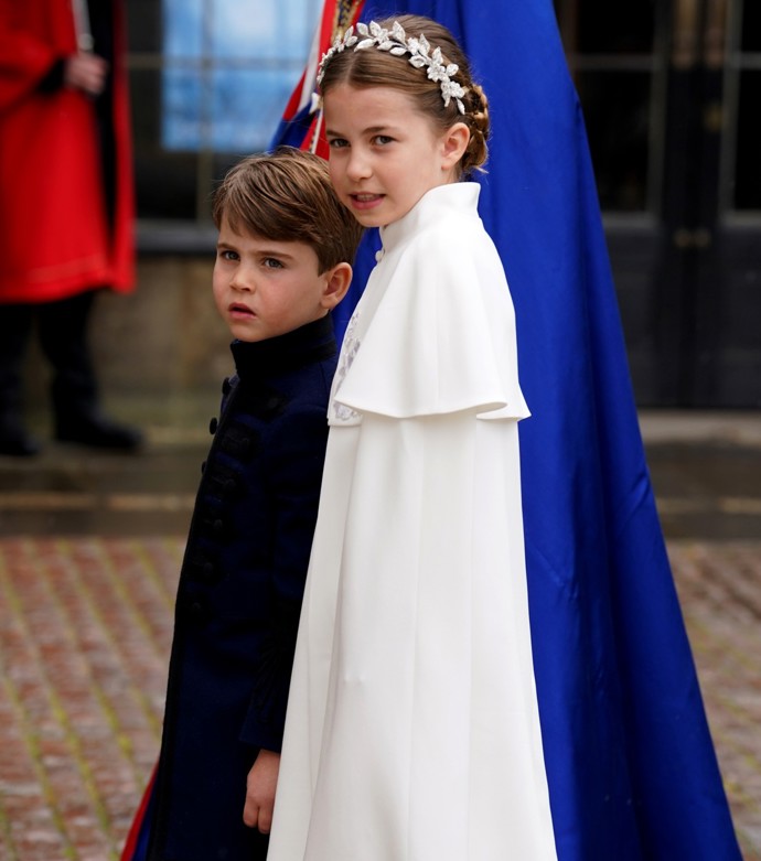Do bílé barvy byla oděna i dcera princezny a prince z Walesu Charlotte (8). Také ji zdobila menší obdoba čelenky, kterou měla na hlavě Kate. Na korunovaci přišla za ruku s bratrem Louisem (5), George měl ve Westminsterském opatství jinou roli už v uniformě.
