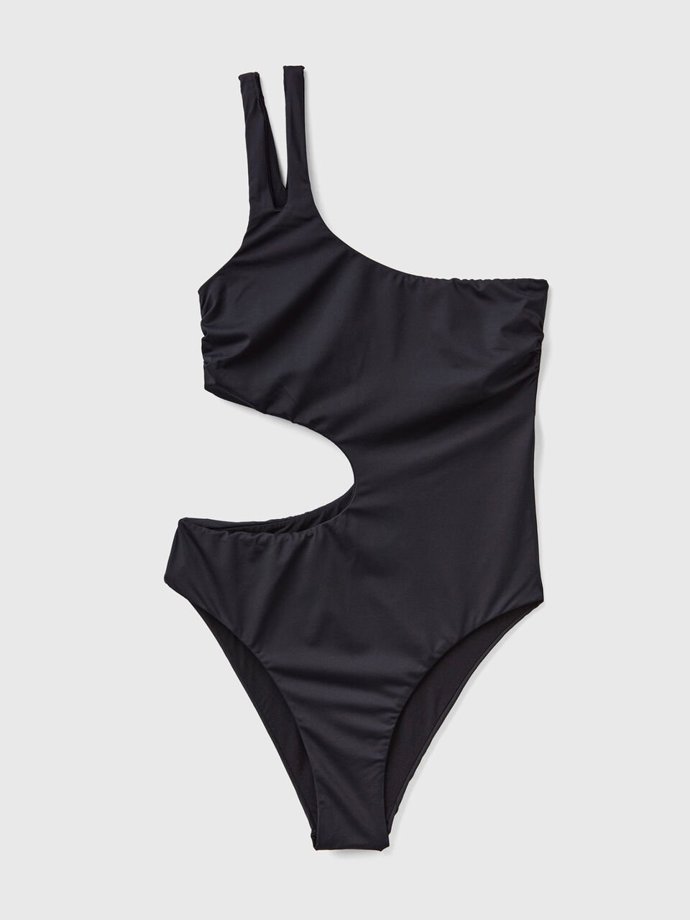 Průstřihy a asymetrie. Vystačíte si s jednoduchým tónem černé, když vybavíte jednodílné plavky takovým arzenálem nepřehlédnutelných prvků. (Benetton, 1 299 Kč)