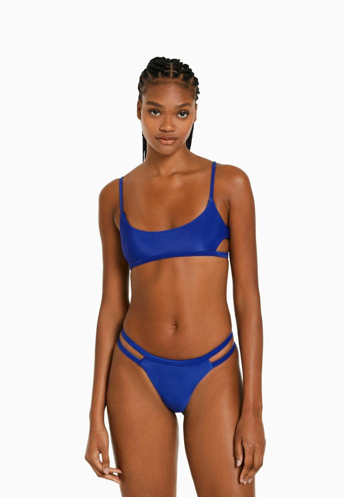 Sportovní prvky se mohou s těmi elegantními mile prolínat. Jednoduché bikiny s páskovými detaily Bershka, vrchní díl za 399 Kč, spodní za 299 Kč.