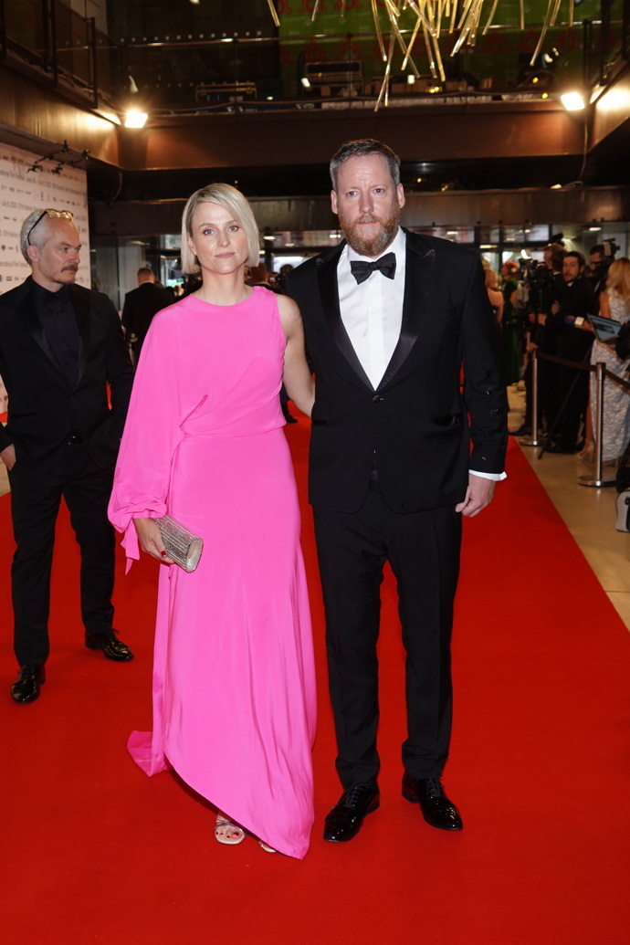 Výkonný ředitel filmového festivalu v Karlových Varech Kryštof Mucha s manželkou, Její růžová róba patří k nejlepším modelům, které se dnes na červeném koberci před Thermalem předvedly.