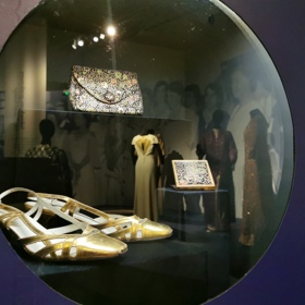 Dobová sbírka doplňků Ireny Svobodové. Kabelka s pudřenkou, kterou jí darovala dcera Zoe, a stylové zlaté střevíčky z kůže.