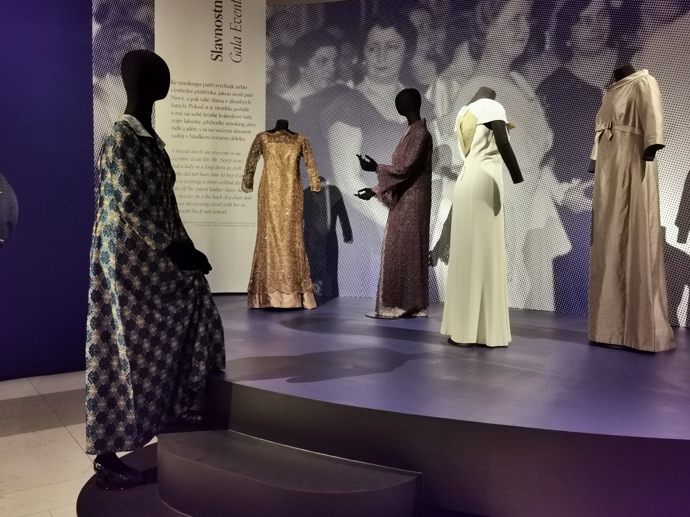 Zlaté společenské šaty s živůtkem a mašlí tak v expozici stojí po boku modelů Hany Benešové nebo Ireny Svobodové.