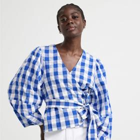 Zavinovací halenka s balonovými rukávy a vázačkou ožila i pod výraznou modrobílou kostkou. (Lindex, 599 Kč)