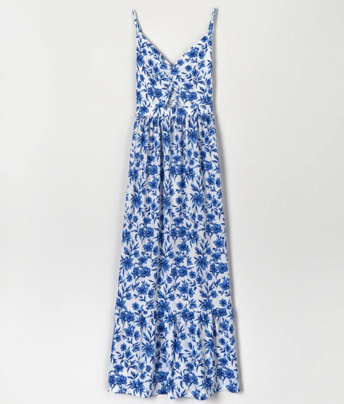 Maxišaty nesmí zůstat opomenuty. A když je zdobí zajímavé střihové řešení odhalující kůži, modré vzory květů jsou už jen pěkným barevným zpestřením. (Sinsay, 479 Kč)