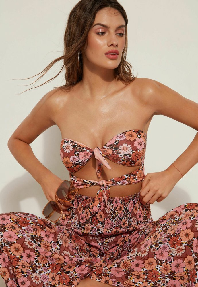 Podprsenka s odnímatelnými ramínky a vázacím detailem může zastupovat i oblíbený bandeau top a ladit se zbytkem outfitu vzorem i střihem. (Tezenis, 449 Kč)