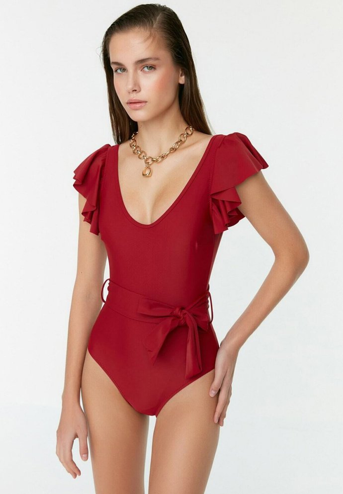 Volánkové rukávy zjemňují impozantní výstřih plavek Trendyol za 946 Kč.