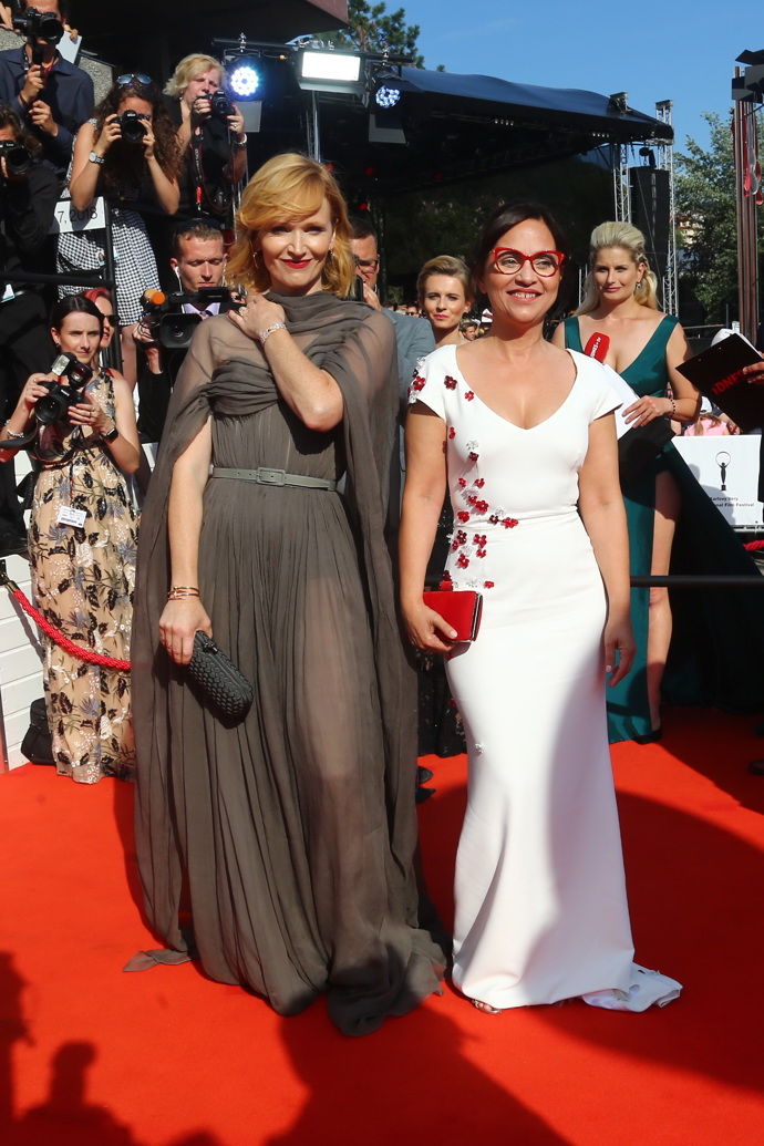 Velkou večerní, která nekřičí zdobností, přesto umí ohromit, připravila Aně Geislerové pro slavnostní zahájení v roce 2018 návrhářka Ivana Mentlová. O doprovod se herečce na snímku postarala její kolegyně Alena Mihulová a také jí to velmi slušelo.