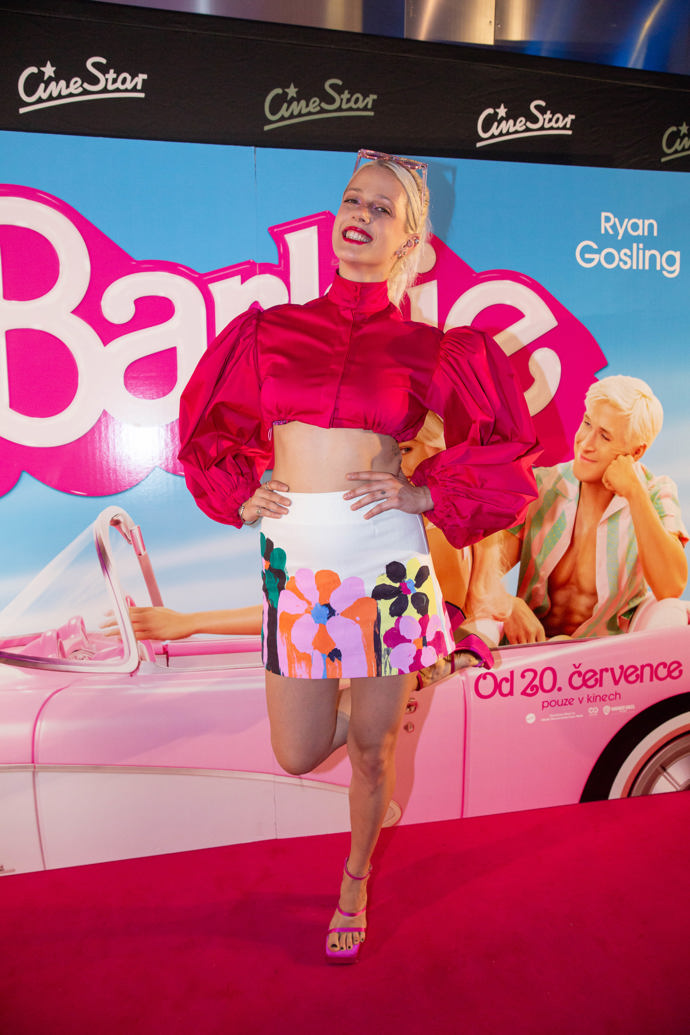 Terezie Kovalová oblékla tmavě růžový top s nabíranými rukávy, přičemž odhalila štíhlé bříško. Sukně hraje všemi barvami a Terezie ji doplnila růžovými střevíčky na vysoké platformě.