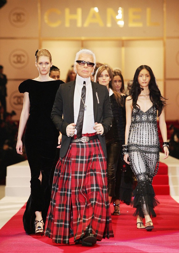 Dlouhou károvanou sukni oblékl i velikán na poli módy, zesnulý návrhář Karl Lagerfeld. Zde například prochází molo se svými modelkami během prezentace kolekce Chanel jaro/léto 2005 v provizorním hledišti v parku Hibiya v centru Tokia.