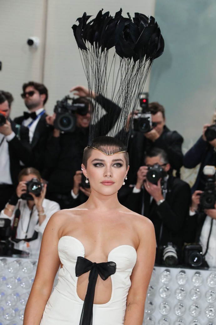 Florence Pugh upoutala vysokánskou pokrývkou hlavy s peříčky.