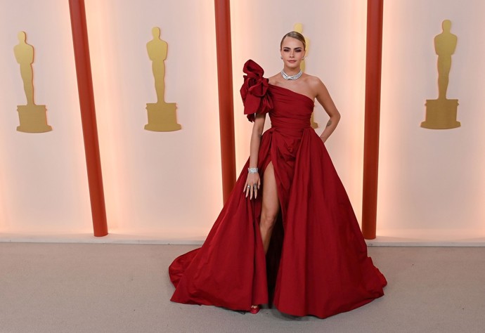 Slavnostní róbu na Oscary v trendy odstínu červené zvolila letos i modelka a herečka Cara Delevingne.