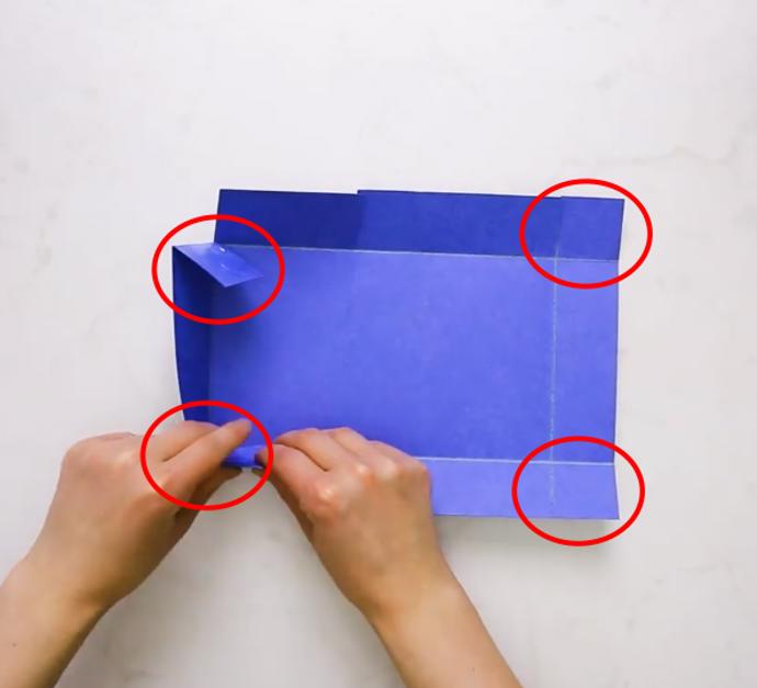 Přeložíme okrajové svislé proužky čtvrtky směrem dovnitř a naneseme lepidlo na lícovou stranu zakroužkovaných míst. Ta přilepíme k vnitřní straně vodorovných proužků čtvrtky.