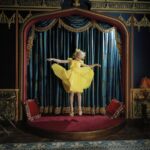 Malá ruská dívenka jménem Varvara si hraje ve svém domácím divadle (ze série „Little Adults“ od Anny Skladmann).